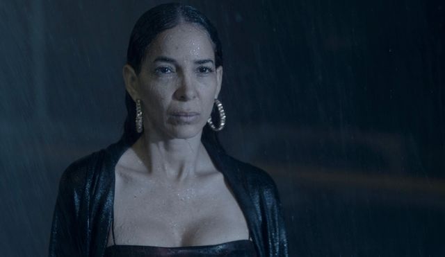 Escena de «Qué más puedes hacerme»: una mujer de mirada fija bajo la lluvia