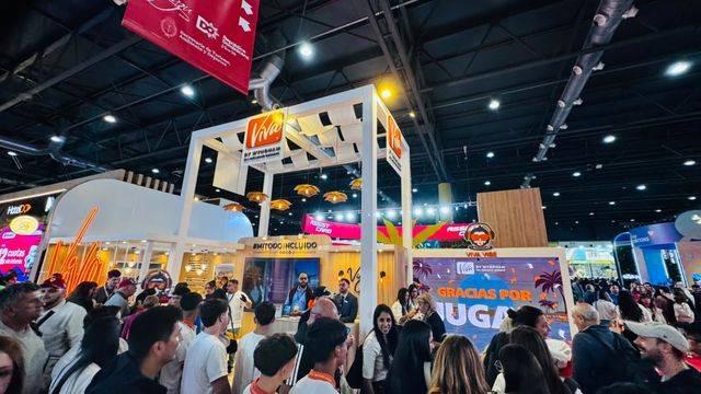 Visitantes recorren el stand de Viva Resorts en la feria