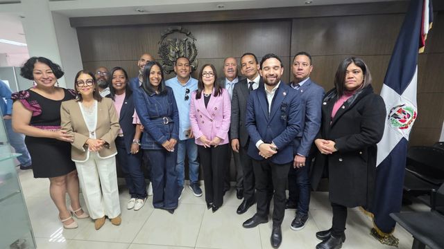 Funcionarios consulares e invitados especiales junto a la bandera dominicana en el Consulado General en Bogotá