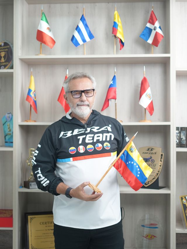 Elías Beirouti con chaqueta del Bera Team y una bandera de Venezuela en la mano