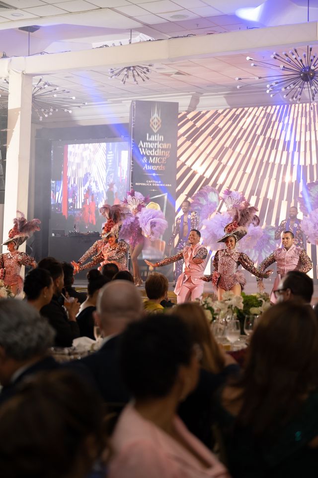 Bailarines en la tarima ante las mesas del salón durante la gala