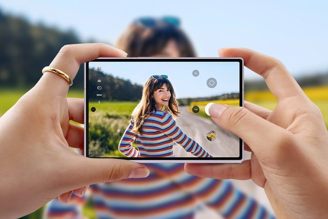 Unas manos sostienen un Galaxy Z Fold abierto mientras toman una foto al aire libre