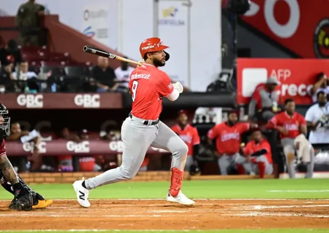 Jonathan Guzmán, con el número 9 de los Leones del Escogido, sale corriendo tras conectar ante los Gigantes