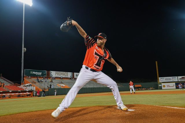 Evan Grills lanza con el uniforme naranja de los Toros del Este en el Estadio Francisco Micheli de La Romana