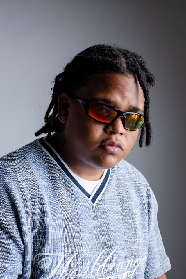 Damn Goldo con gafas rojas y suéter claro