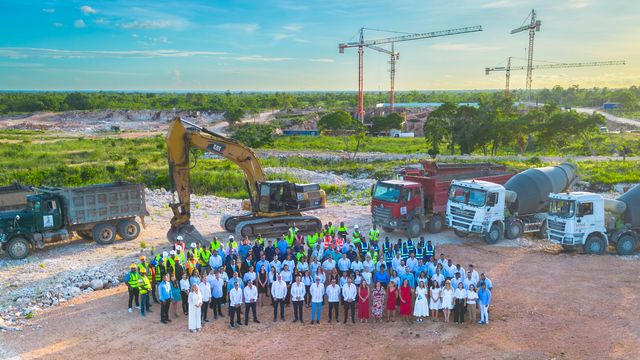 Equipo de CLERHP posa junto a maquinaria y camiones en el terreno de Larimar City & Resort, con grúas al fondo