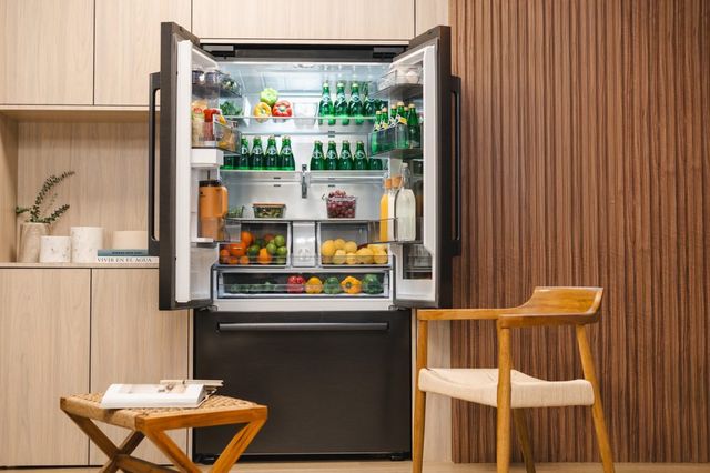 Nevera Samsung de puertas francesas abierta y llena de alimentos en una cocina