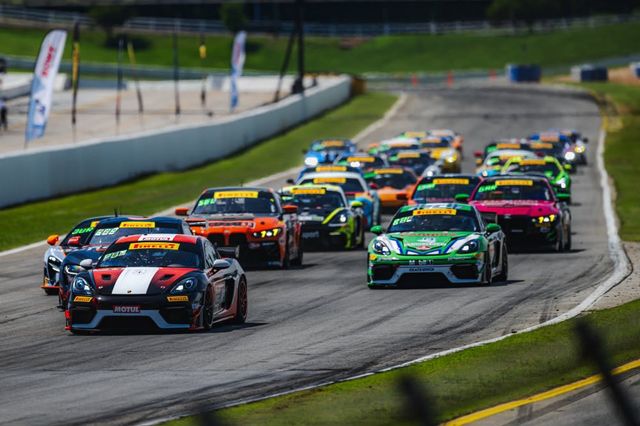 Varios autos compiten en grupo en una curva del circuito