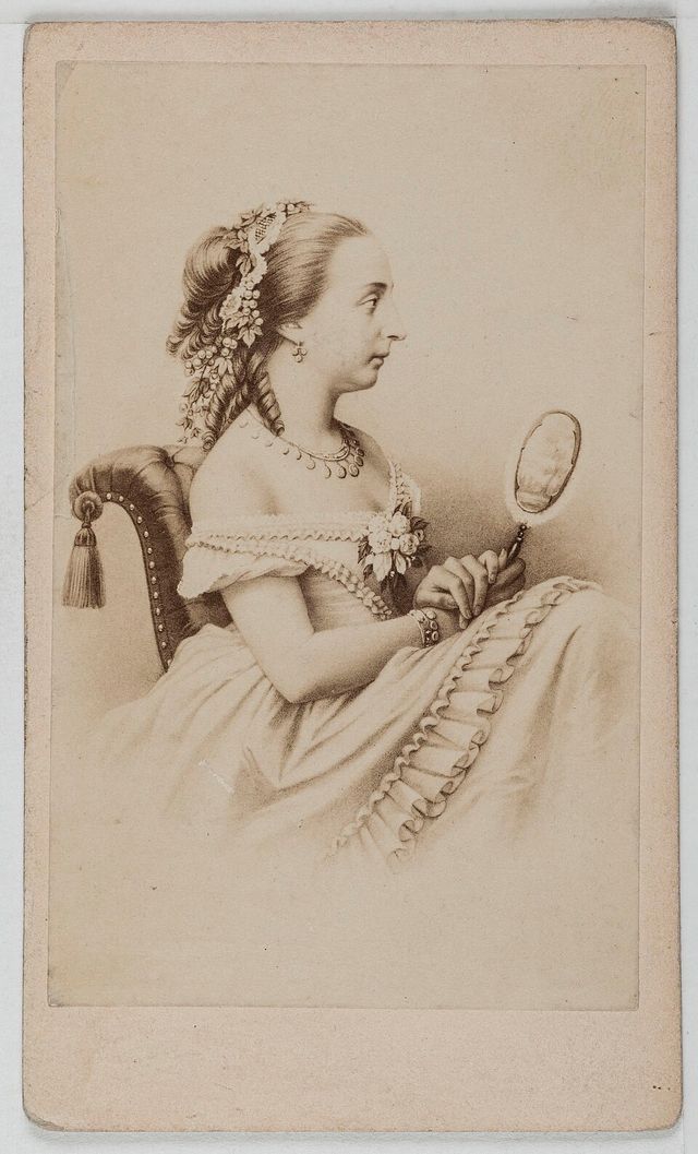 Retrato de perfil de María Isabel de Orleans, condesa de París, sentada con un espejo de mano y flores en el peinado