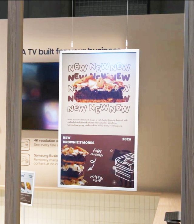 Póster digital Samsung Color E-Paper colgado en una vitrina con una promoción de brownies