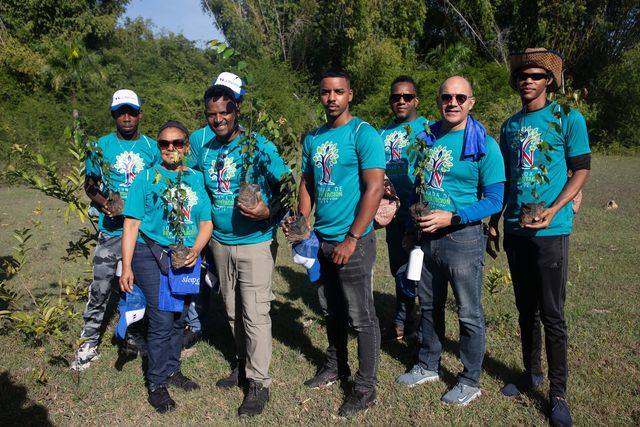 Un grupo de voluntarios de La Nacional sostiene plántulas para sembrar