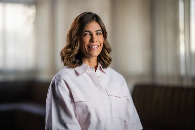 Jennifer Inmaculada Ramos Concepción, con camisa blanca, sonríe en una sala