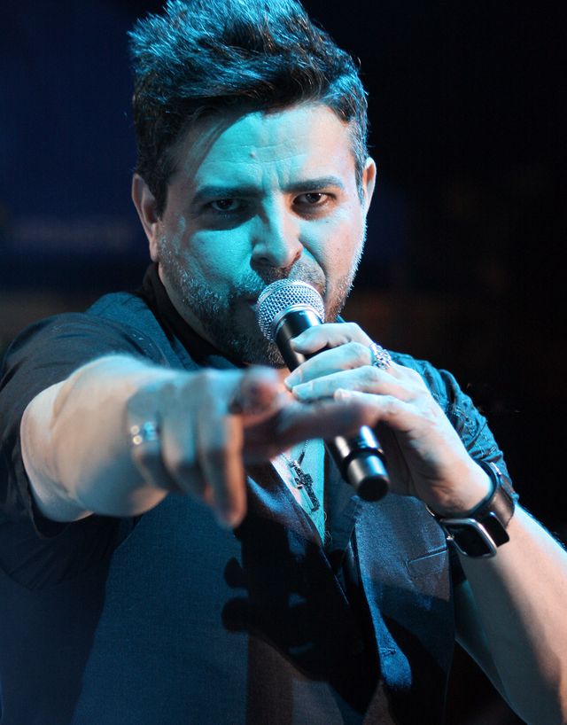 El cantante nicaragüense Luis Enrique canta con el micrófono en la mano y señala al público durante un concierto