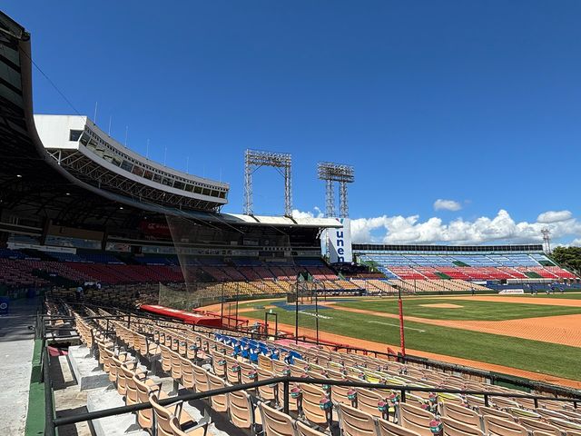 Gradas vacías y terreno del Estadio Quisqueya Juan Marichal bajo un cielo azul