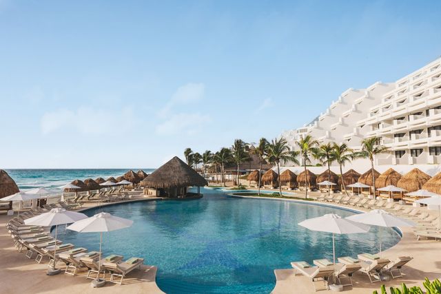 Piscina Celsius de Paradisus Cancún, rodeada de palapas y camastros frente al mar