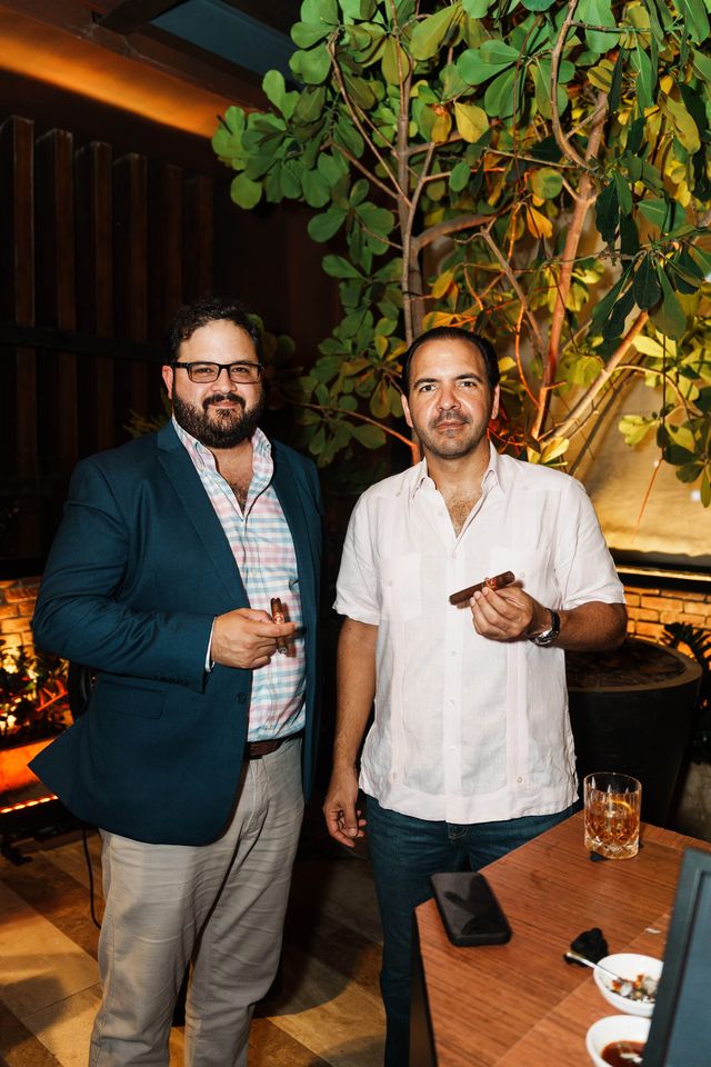 Raúl Báez y Miguel Toirac con cigarros en la terraza de La Bodega