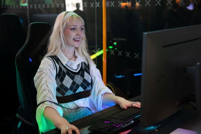 Joven jugadora frente a un monitor gaming iluminado en un evento de Samsung Odyssey