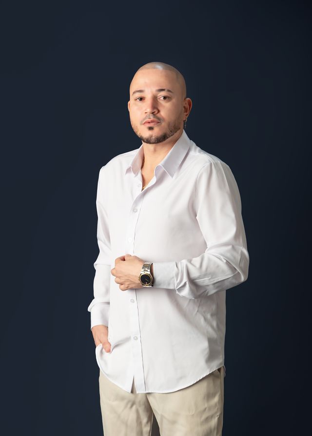 Nacho Estrella con camisa blanca sobre fondo azul oscuro