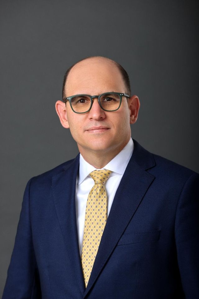 Edgar Del Toro, presidente ejecutivo de Banco Caribe, con traje azul y corbata amarilla