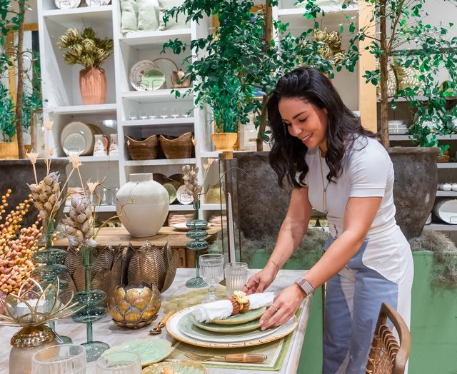 Priscila Sánchez acomoda un plato en una mesa de la colección