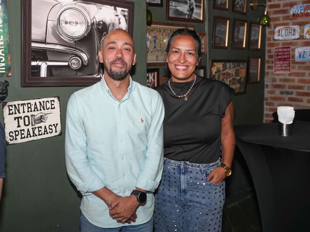 Eduardo Santos y Naishme De Los Santos junto al letrero del speakeasy