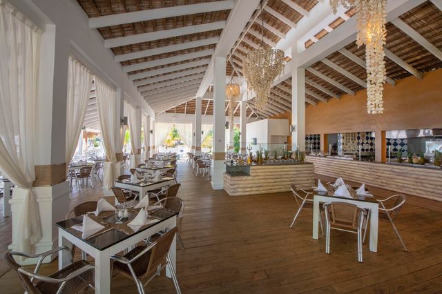 Restaurante techado con mesas y vista al jardín en Viva Heavens