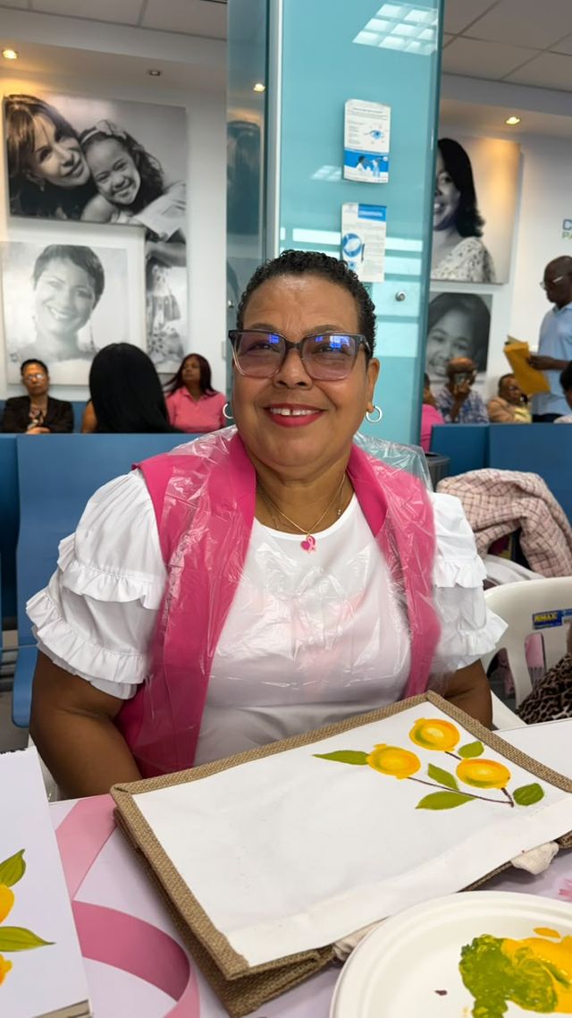 Una participante sonríe junto al bolso decorado con flores amarillas