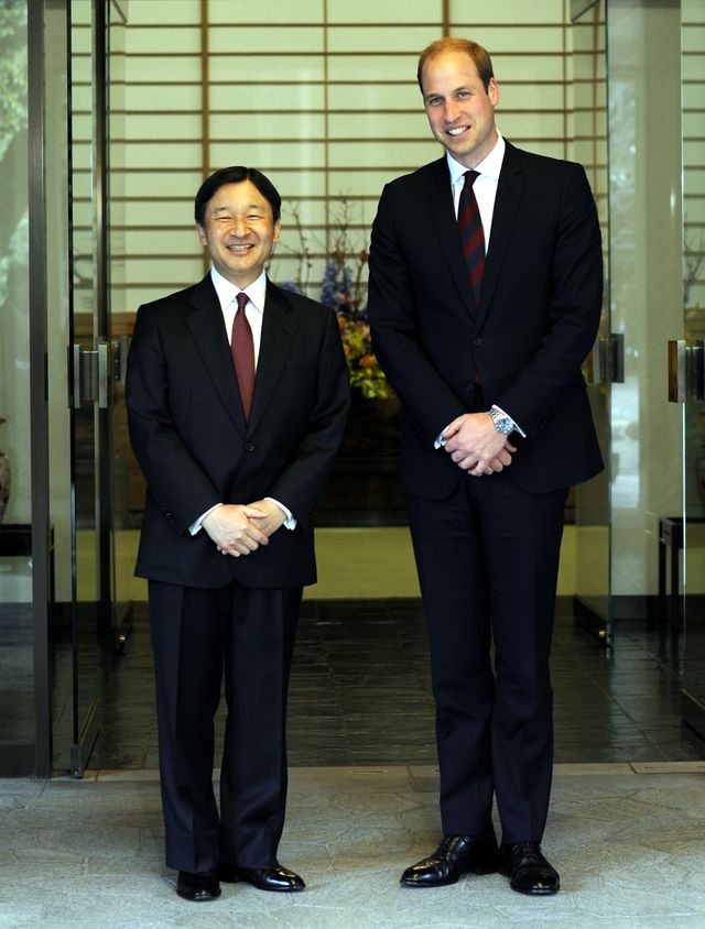 El príncipe Guillermo, de traje oscuro, sonríe junto al entonces príncipe heredero Naruhito durante su visita a Tokio en febrero de 2015