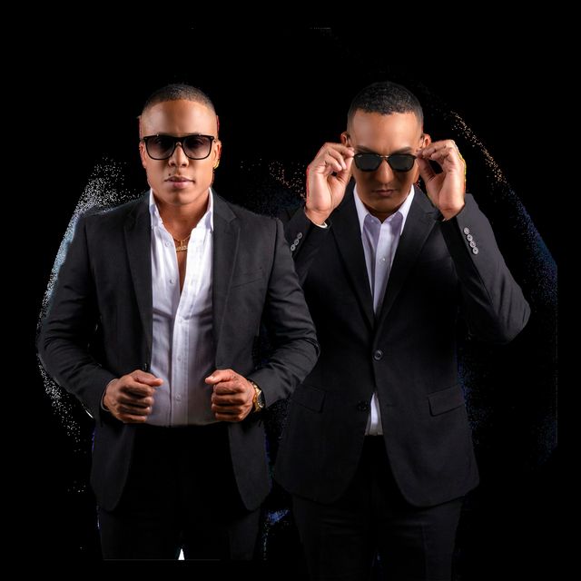 Rafael Berroa «Chiquito» y Enmanuel Frías, de traje oscuro y lentes