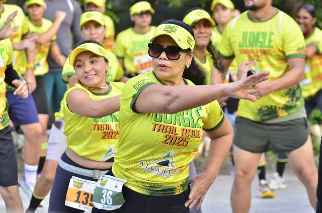 Participantes con camisetas amarillas de la Jungle Trail Race 2025 calientan antes de la carrera