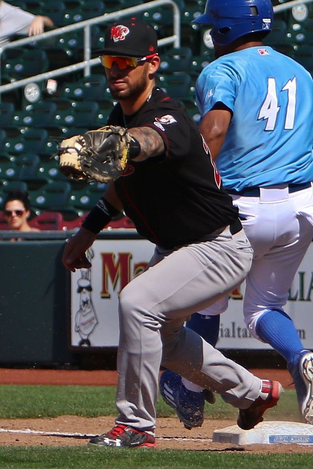 Jorge Bonifacio, con el número 41 y el uniforme de Omaha, corre hacia la primera base mientras Rangel Ravelo recibe la pelota, en 2016