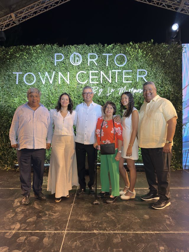 La familia Bretón frente al muro verde con el logo de Porto Town Center
