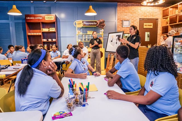 Estudiantes dibujan con lápices de colores en un taller de arte