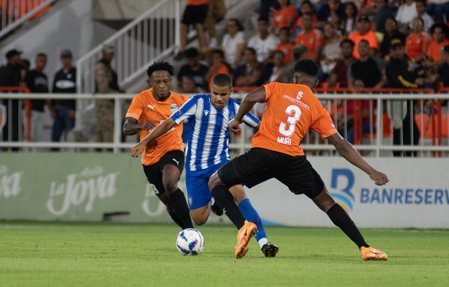 Emmanuel Cuello, de azul y blanco, conduce el balón entre dos jugadores de Cibao FC en la final de la LDF de 2024