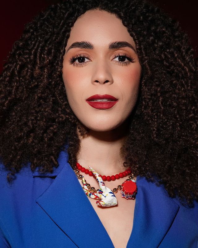 Retrato de la actriz dominicana Lía Lockhart con chaqueta azul y collar rojo