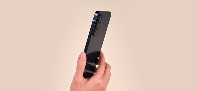 Una mano sostiene de perfil un Galaxy A57 5G sobre fondo beige