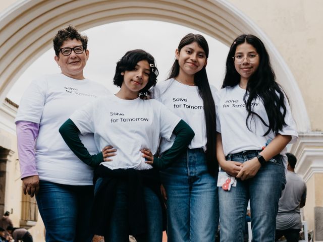 Participantes de Solve for Tomorrow con camisetas del programa bajo un arco colonial
