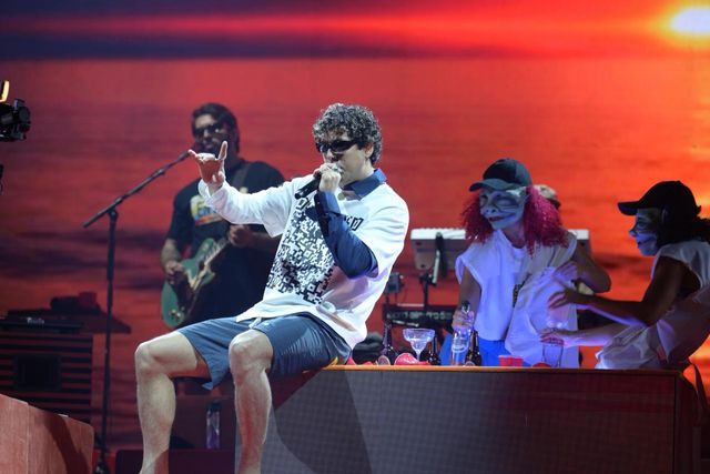 Rawayana interpreta sentada sobre la tarima, acompañada de sus músicos