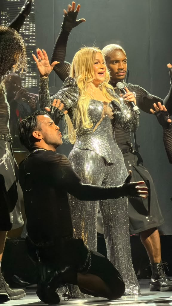 Miriam Cruz, con un traje plateado, rodeada de sus bailarines