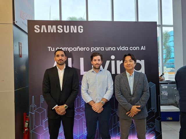 Cuatro personas posan frente a un panel de Samsung AI Living