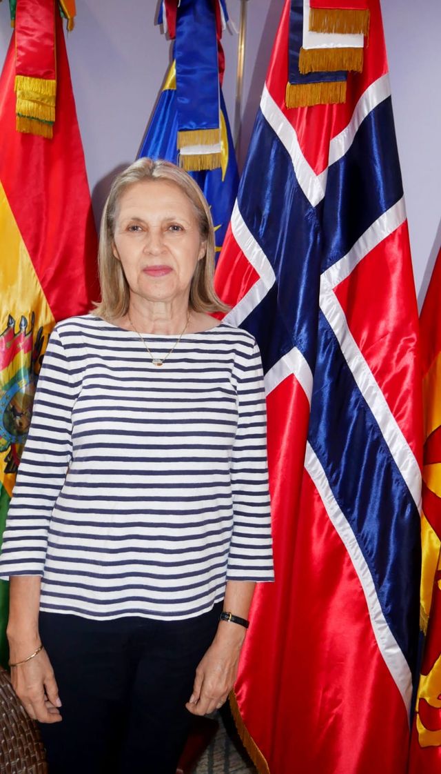 Clara Read de Frankenberg, cónsul honoraria de Noruega, junto a la bandera noruega
