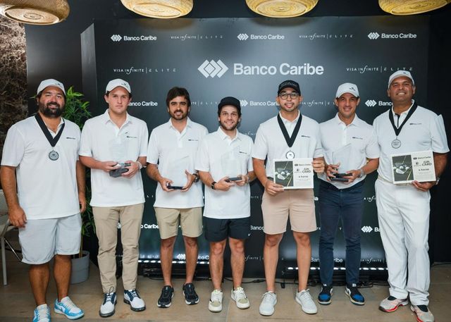Ganadores del Torneo Golf Virtual Caribe posan con sus premios frente a un mural de Banco Caribe