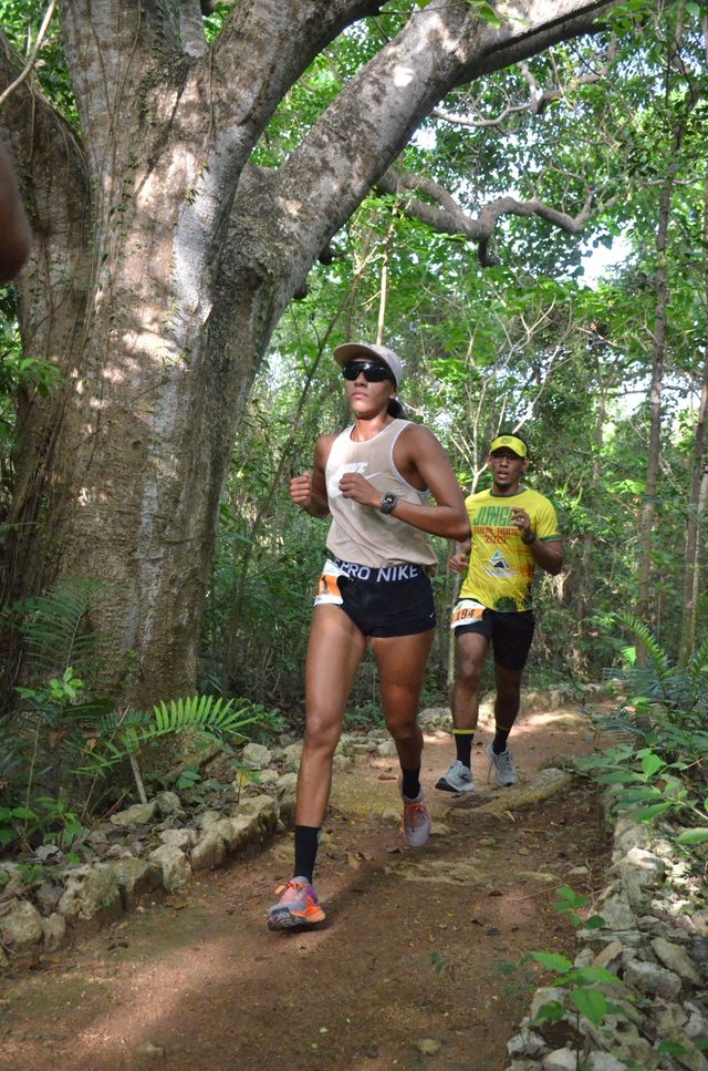Una corredora avanza por un sendero entre árboles en Bávaro Adventure Park