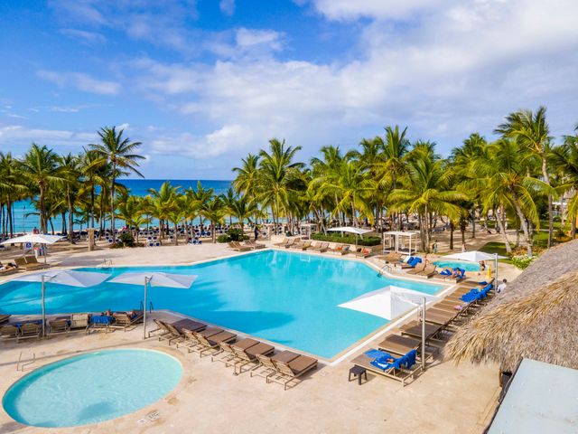 Piscina rodeada de palmeras en Viva Dominicus Palace by Wyndham