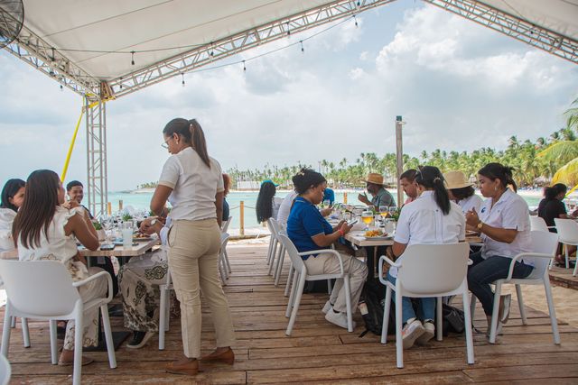Invitados almuerzan en una terraza techada frente al mar en Viva Dominicus Palace