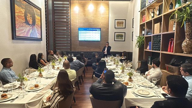 Invitados del sector financiero sentados en mesas largas durante el evento de Business IT en Cava Alta