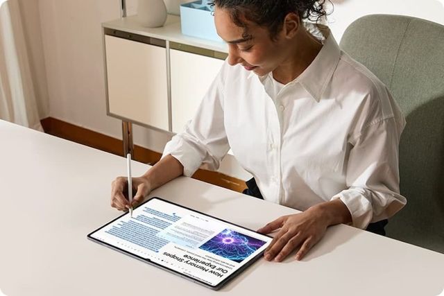 Una mujer toma apuntes con el S Pen sobre un artículo abierto en la Galaxy Tab S12