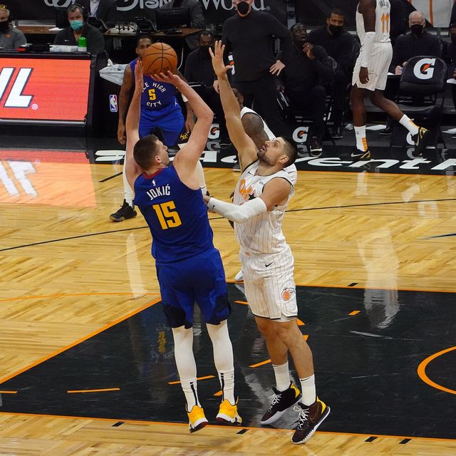 Nikola Jokić lanza en suspensión sobre Nikola Vučević en un partido de los Nuggets ante el Magic en 2021
