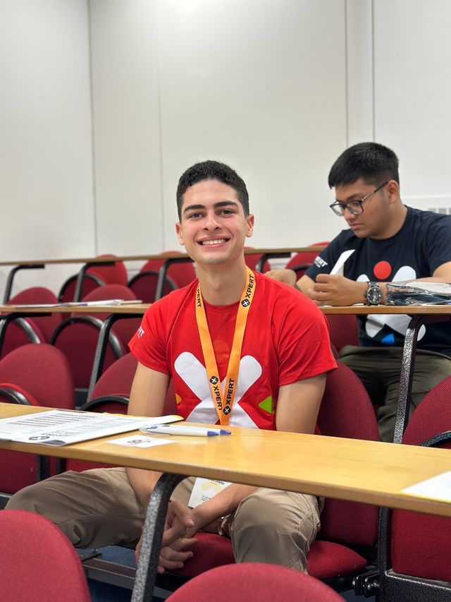 Un estudiante dominicano sonríe en su pupitre durante la XPERTSTEM Elite Final