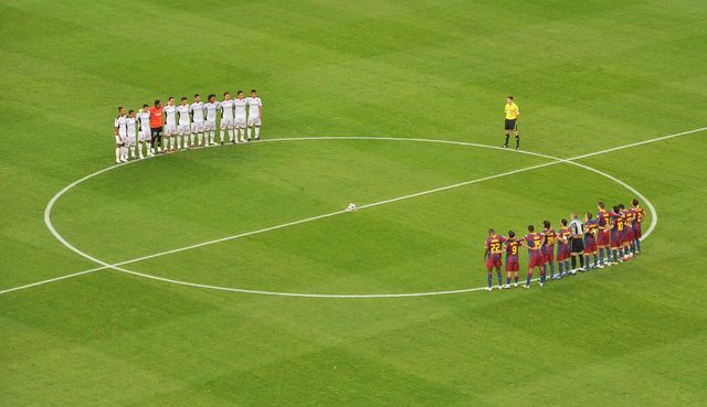 Los jugadores del Barcelona y del Mallorca, alineados en el círculo central del Camp Nou antes de un partido de liga en 2010